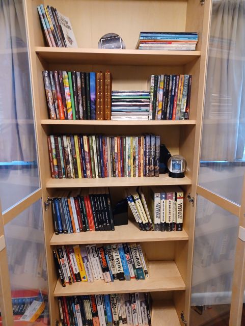 A mostly full bookcase holding one copy of every edition and translation of every book I've written.