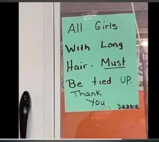 Hand written sign reading: "All girls with long hair must be tied up"