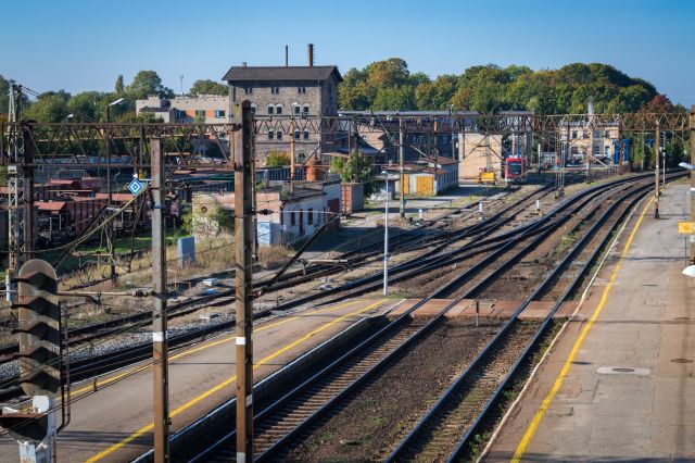View from a footbridge over the train tracks towards technical buildings and sidings near the Krzyż station