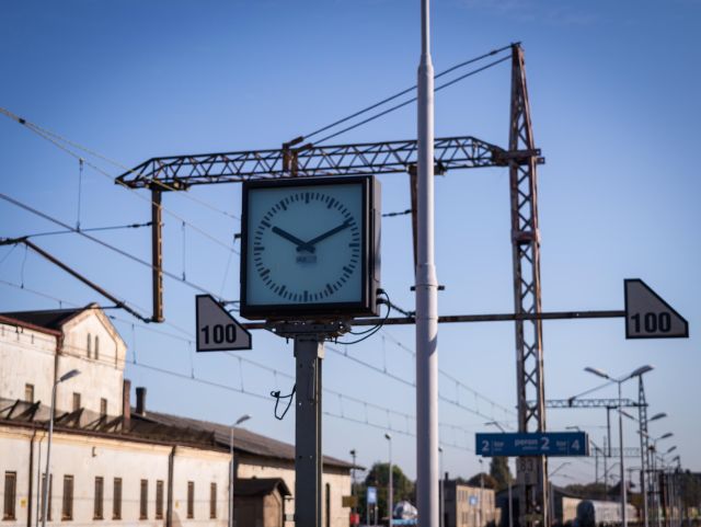 An analog clock on a platform of a train station