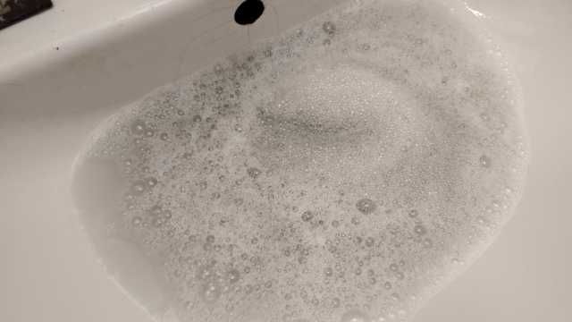 Dreckiges Schaumwasser im Waschbecken.