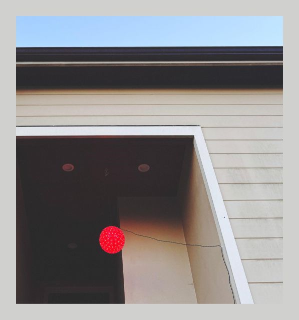 We see an intriguing geometric composition of complementary beige and brown angular shapes; and near the lower left corner is a bright red glowing orb floating in the space. — Now, what we are actually looking at is the entryway to a house from around the block that still has its Christmas lights up at the end of January (which to be real, is totally fine by me… I mean you know with all the other red lights they have up across the yard, maybe this could easily work equally as well for Valentines Day too? I’m all for it.) Either way, what caught my eye walking past it was the really great interplay of pale light blue sky and light cream-colored wood siding with the dark mahogany accents and the off-white trim, along with the oversized doorway and that fancy light hanging there like a little red beacon of joy. Just magical. 